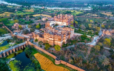 Aerial view of the Orchha Fort, river, and surrounding green landscape